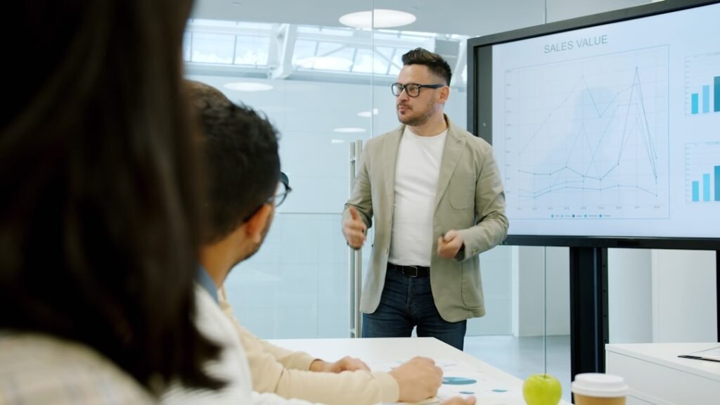 A leader presenting to colleagues using a screen in a meeting room
