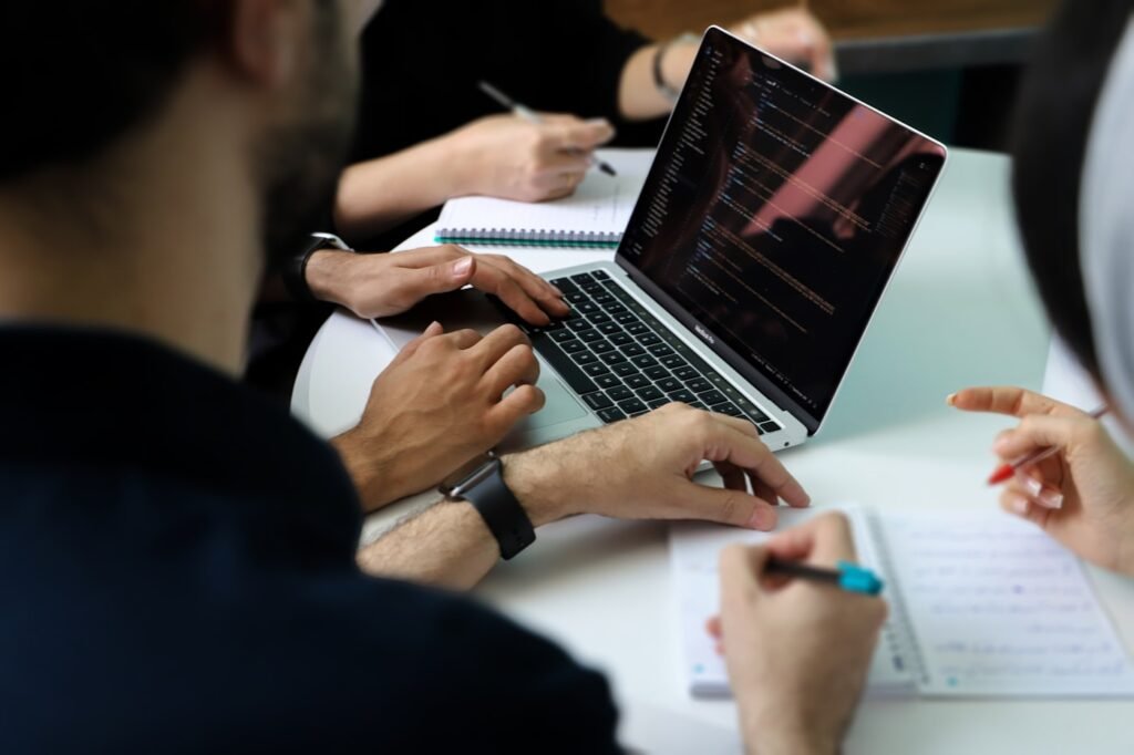 Cross-functional team working through analysis together with laptops and notes