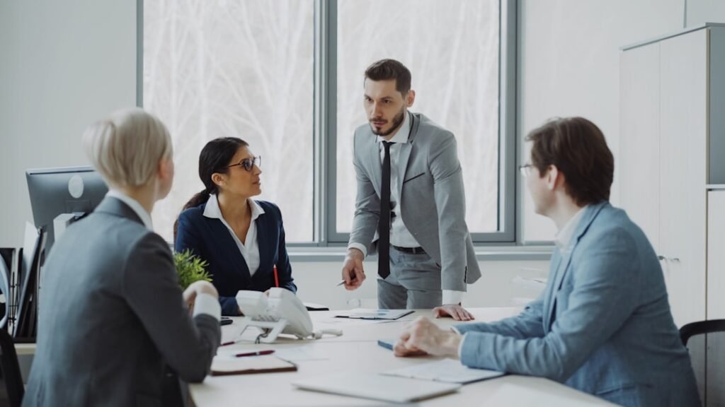 Colleagues reviewing reports and contract terms around a meeting table